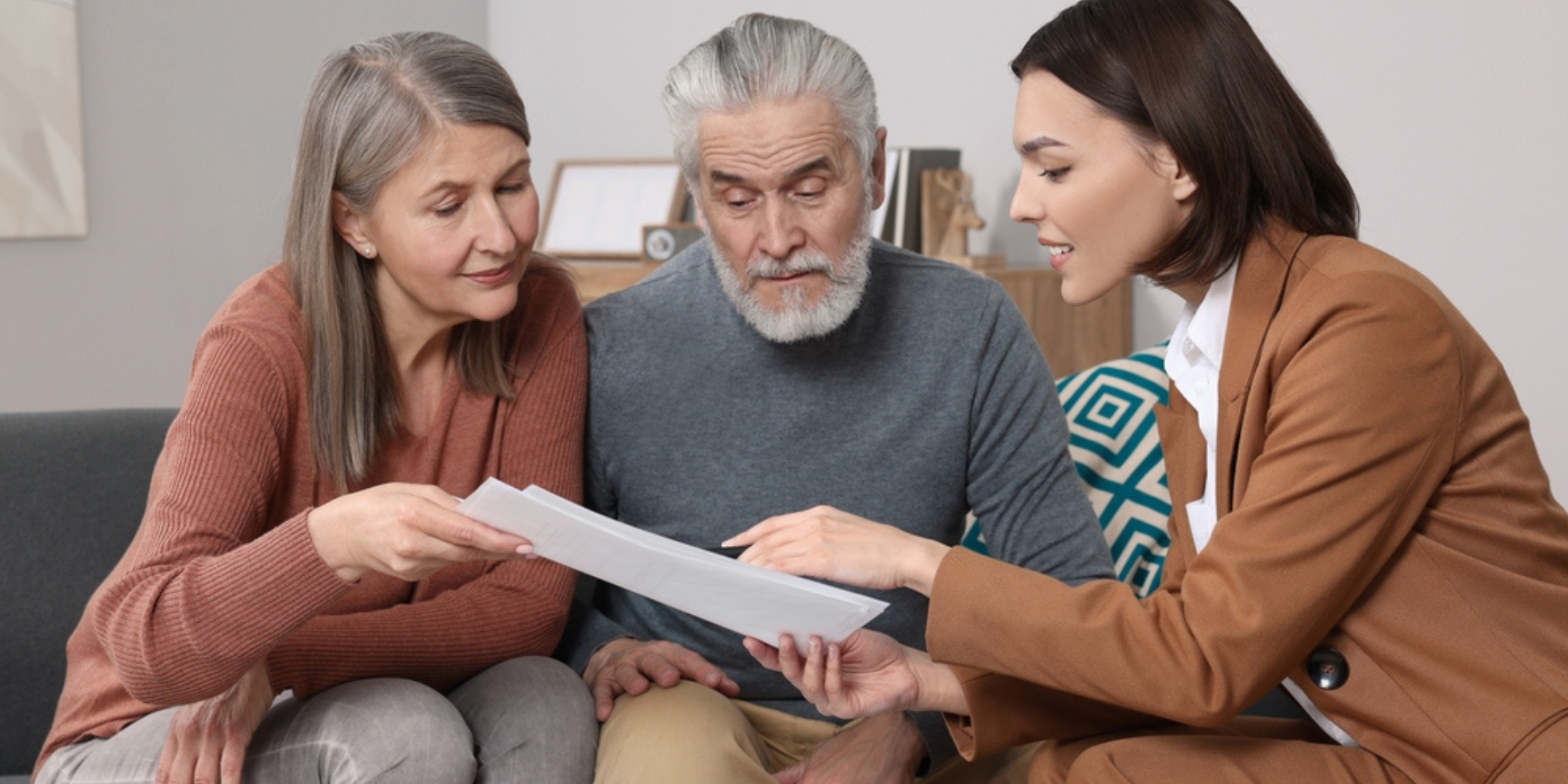 Licensed insurance agent assisting senior clients with Medicare plans during the Annual Enrollment Period, reviewing coverage options together.